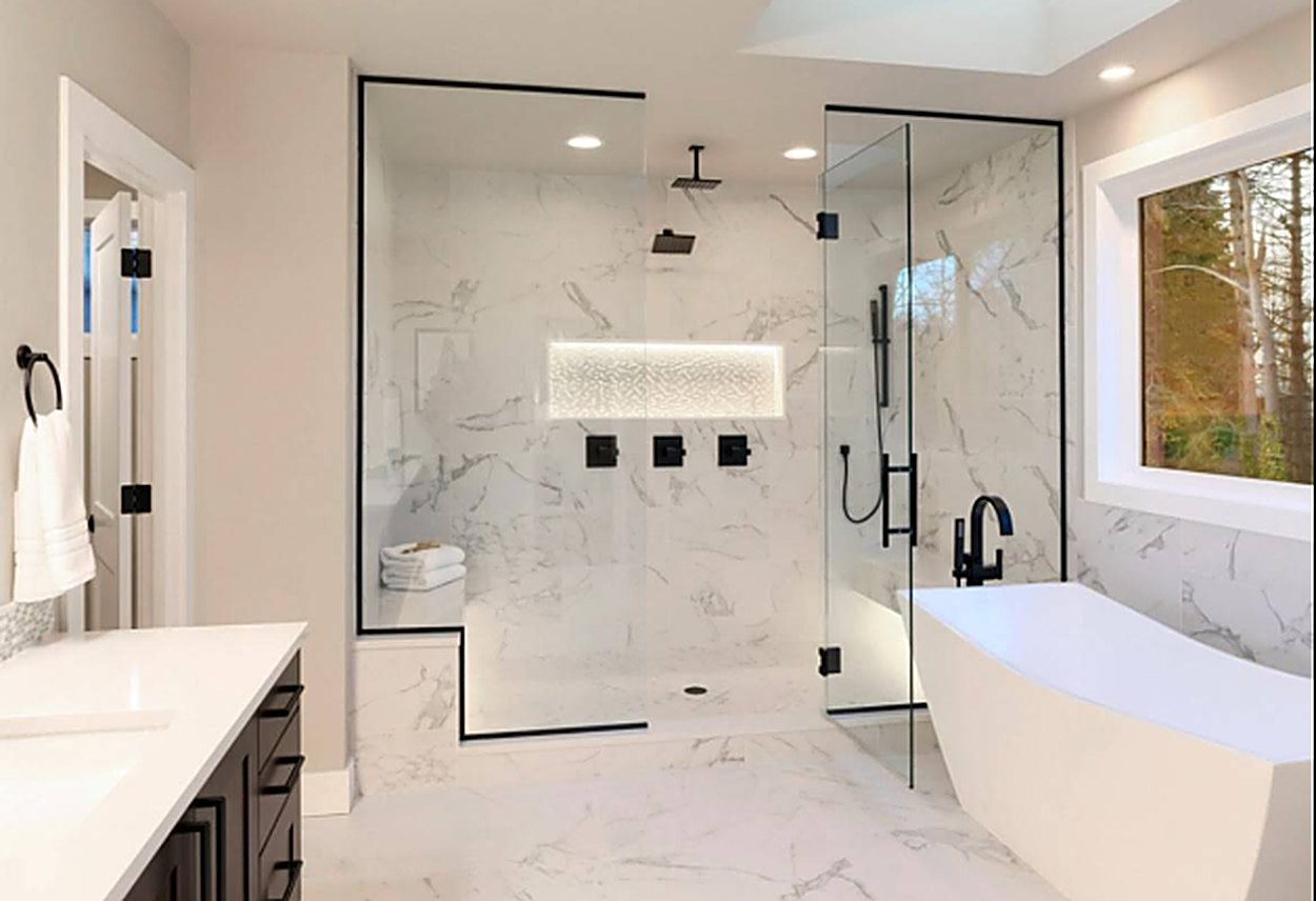 Finished luxury master bathroom with marble tile, freestanding tub, and glass walk-in shower