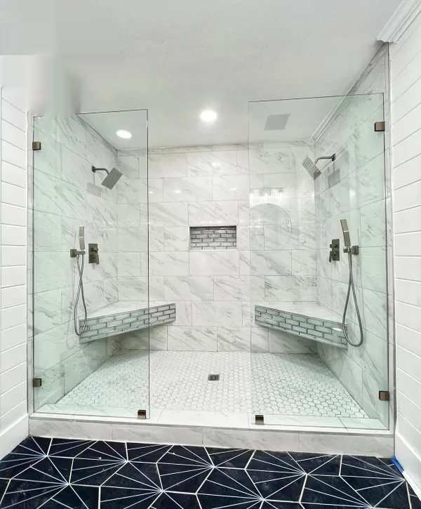 Two-person marble walk-in shower with dual shower heads and hexagon tile floor